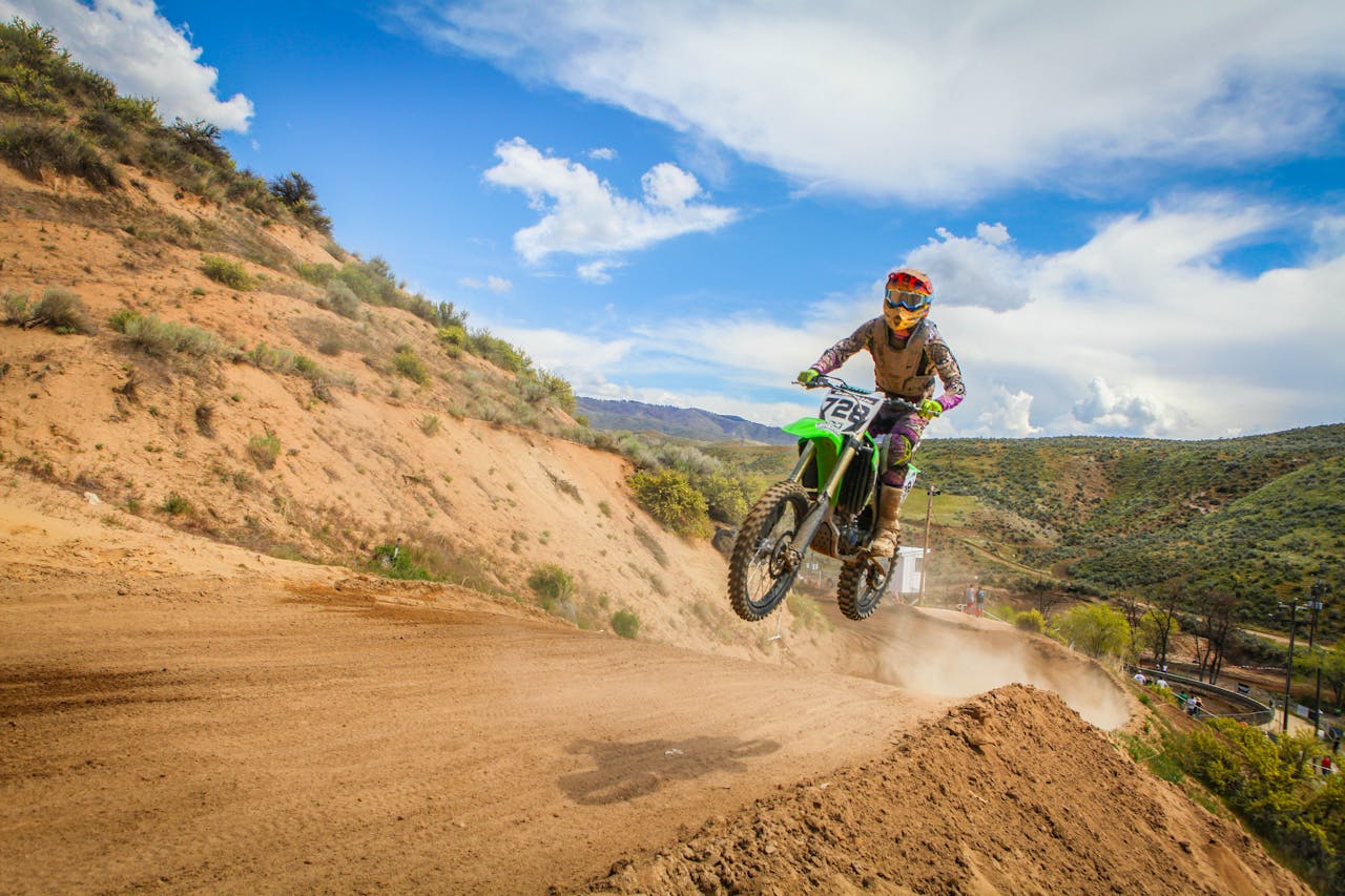Exciting motocross action with a biker jumping on a dirt track during a race.
